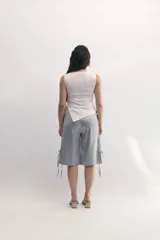 Bermuda gris satinada con corte recto, cintura elastizada, bolsillos frontales y tiras laterales para ajustar.