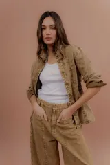 Chaqueta de jean azul, de corte entallado, con cuello camisero, cierre frontal con botones y bolsillos delanteros con solapa.