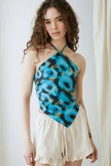 Top halter confeccionado en tafeta, con diseño estampado en tonos de azul y negro, y terminación en punta en la parte inferior.