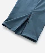 Pantalón de corte holgado en color azul petróleo, confeccionado en microfibra de poliéster. Presenta un diseño utilitario con múltiples bolsillos funcionales, cierres visibles y detalles técnicos en las piernas.