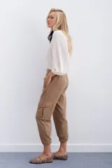 Pantalón de corderoy gris, de fit holgado con elástico en cintura y puños. Presenta bolsillos aplicados en el delantero.