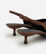 Zapato tipo slingback de punta fina en color marrón, con tira trasera ajustable y tacón bajo tipo kitten heel.