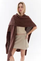 Ruana de punto color beige con detalles texturizados y tramados abiertos, ligera y versátil.