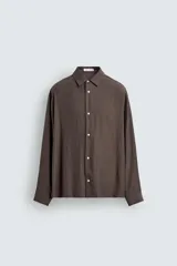 Camisa de corte relajado confeccionada en tejido fluido con mezcla de cupro. Presenta cuello solapa, manga larga con puños abotonados y cierre frontal con botones.