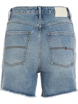 Shorts de jean de tiro alto, color celeste claro, con ruedo desflecado y logo de Tommy Hilfiger bordado en el bolsillo trasero.