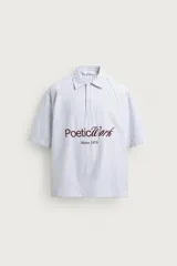 Camisa polo boxy fit de manga corta, confeccionada en tejido de algodón con diseño de rayas verticales celestes y blancas. Cuenta con cuello solapa, cierre frontal con botones y estampado frontal de texto en tono marrón con la leyenda "Poetic Work Since 1975".