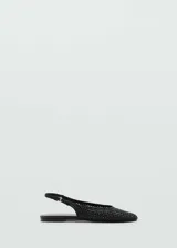 Zapato tipo slingback de color negro con diseño trenzado, punta redonda y cierre de tira con hebilla ajustable en el talón.