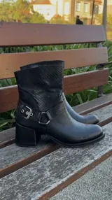 Botas cortas de cuero negro con punta fina y cierre lateral.
