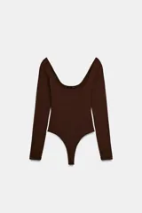 Body de manga larga con escote cuadrado, confeccionado en tejido elástico, con cierre inferior mediante botones a presión.