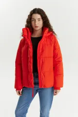 Campera puffer naranja con capucha, cierre frontal con botones a presión y bolsillos laterales. Diseño acolchado y corte corto.