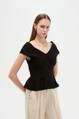 Blusa de lino color blanco, con cuello en V, pinzas de entalle y diseño al cuerpo con faldón acampanado.