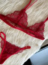 Conjunto de lencería compuesto por un bralette triangular de encaje con breteles regulables y una tanga de encaje regulable con corte media less.