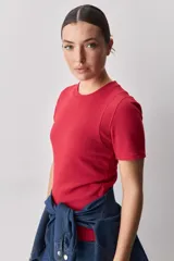 Remera blanca de manga corta y cuello redondo, con calce ajustado al cuerpo y diseño liso y minimalista.