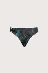 Bombacha de bikini con estampado orgánico de líneas curvas en tonos marrón y turquesa. Presenta un detalle de argolla metálica dorada en el lateral izquierdo con frunces.