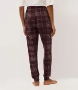 Pantalón de pijama tipo jogger confeccionado en tejido peach touch de color bordó, con estampado de cuadros y pequeños detalles de corazones. Posee cintura elástica con cordón de ajuste en color rosado y puños elastizados en los tobillos.