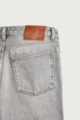 Jeans flare fit de denim negro, tiro medio, ajustados arriba y con botamanga acampanada. Cuentan con cinco bolsillos, lavado efecto gastado y bajo con acabado irregular. Cierre frontal con cremallera y botón.