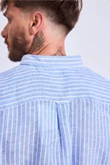 Camisa de corte regular con diseño de rayas verticales finas en tonos claros, cuello clásico y mangas largas con puños abotonados.