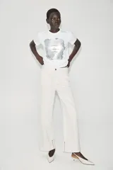 Camiseta blanca de manga corta y cuello redondo, con detalle de estampa central metalizada de efecto texturizado y diseño regular fit.