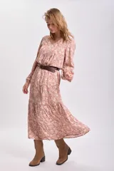 Vestido largo color tostado con estampado floral blanco, corte holgado, mangas largas abullonadas y cinturón marrón.