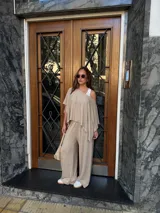 Pantalón de lanilla color beige, de corte recto y tiro alto, con diseño holgado y fluido.