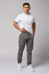Pantalón cargo color beige de gabardina, con corte ajustado, bolsillos laterales con fuelle y puños elásticos en los tobillos.