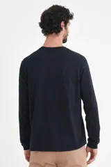 Remera de manga larga con cuello henley y cierre frontal de tres botones. Confeccionada en tejido de algodón, presenta un corte clásico y versátil.