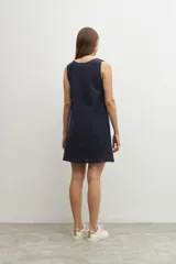 Vestido corto azul marino con bordado floral blanco, sin mangas y corte recto.