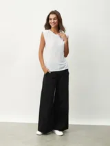 Remera blanca de corte clásico con cuello redondo y mangas cortas con detalle de hombreras.