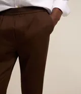 Pantalón de sarga color marrón con textura de espina de pez, corte recto, cintura elástica y bolsillos laterales.