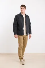Sobrecamisa gris oscuro de manga larga, con cuello clásico, cierre frontal con botones y dos bolsillos de parche en el pecho.