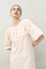 Vestido corto negro con bordado floral blanco, escote redondo con abotonadura frontal y mangas 3/4 abullonadas con pliegues en los hombros.