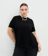 Blusa de manga corta con escote redondo, confeccionada en algodón. Presenta un diseño alargado con un detalle de encaje irregular aplicado en el ruedo, aportando un acabado asimétrico y delicado.
