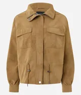 Campera Blue Steel de poliuretano con textura aterciopelada de efecto gamuza, color tostado. Cuenta con cuello alto, cierre frontal con solapa y botones a presión, bolsillos frontales con tapa y cordón ajustable en la cintura.