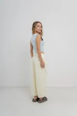 Pantalón 3/4 estilo palazzo confeccionado en denim liviano de tono amarillo pastel, tiro medio con pliegues delanteros, bolsillos delanteros y traseros aplicados, con detalle de logo metálico PEACH en la parte posterior.