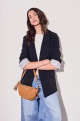 Blazer negro de corte clásico con solapas y mangas largas con puños con rayas verticales.