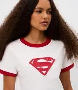 Remera de algodón blanca de corte ajustado, con cuello redondo y ribetes en las mangas de color rojo. Cuenta con un estampado frontal localizado del logo de Supergirl.