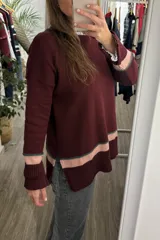 Sweater tejido color bordó con detalles de franjas en rosa pálido y verde en puños y ruedo. Presenta cuello redondo y diseño de calce holgado.