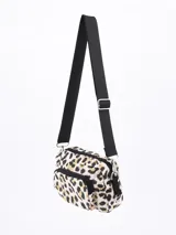 Bandolera rectangular con estampado animal print de leopardo en tonos beige, negro y dorado. Tiene un bolsillo frontal con cierre y correa larga regulable.