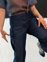 Pantalón babucha de denim azul, con corte a la cintura baja y diseño tipo origami. Presenta pliegues y costuras que favorecen la silueta. Creado y producido en Uruguay.