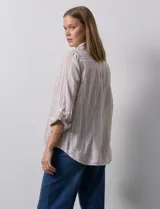 Camisa de lino marca Dash, color beige con rayas verticales blancas, cuello con solapa, cierre frontal de botones, bolsillo aplicado en el pecho y mangas largas con sistema para arremangar mediante presilla y botón.