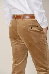 Pantalón de pana de corte clásico, color tostado, con cierre de botón y cremallera, bolsillos laterales y traseros.