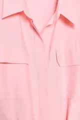 Vestido camisero midi color rosa pálido, con cuello solapa, manga corta y bolsillos de plastrón en el pecho. Incluye un cinturón de lazo en el mismo tejido.