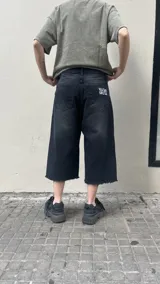 Bermuda de jean negro, corte ancho y largo a la rodilla.