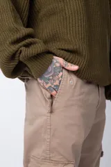 Pantalón cargo color beige, con bolsillos laterales tipo cargo con solapa y cierre de botón, corte recto y ajuste cómodo.
