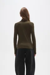Polera de cuello alto y manga larga, confeccionada en tejido de viscosa con elastano, de corte ajustado al cuerpo.