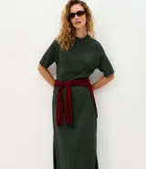 Vestido midi Marfinno de punto color verde oscuro, de corte amplio y relajado, con cuello alto y mangas cortas amplias.