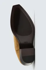 Bota de piel color marrón claro, estilo cowboy, con caña corta, puntera en punta y tacón cubano.