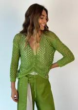 Top tejido calado color celeste, con escote en V y mangas largas.