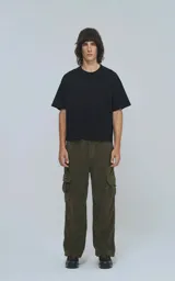 Pantalón cargo de corderoy color verde militar, de calce regular y diseño unisex. Presenta cintura elástica, bolsillos laterales y bolsillos tipo cargo con solapa en los laterales de las piernas.