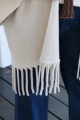 Saco abierto de corte recto y holgado, color visón, con mangas tres cuartos y detalle de flecos largos en el ruedo.